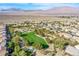 Serene aerial view of a community featuring a lush green park, neighborhood pools, and mountain views at 9831 Running Rabbit St, Las Vegas, NV 89143