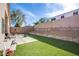 Large backyard features artificial turf, patio with furniture, rock garden, and a secure brick wall for privacy at 9831 Running Rabbit St, Las Vegas, NV 89143