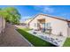 Expansive backyard showcases lush artificial grass, a paved patio with furniture, rock garden, and block wall at 9831 Running Rabbit St, Las Vegas, NV 89143