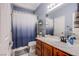 Bathroom with single sink vanity, large mirror, and a shower-tub combo with blue-themed shower curtain at 9831 Running Rabbit St, Las Vegas, NV 89143