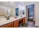 Bathroom with dual sinks, a large mirror, and views into the primary bedroom at 9831 Running Rabbit St, Las Vegas, NV 89143