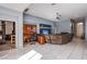 A spacious living room area with tile flooring, ceiling fan, and an open doorway to an adjacent room at 9831 Running Rabbit St, Las Vegas, NV 89143