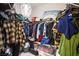 Spacious walk-in closet with ample storage, shelving, and hanging space under a decorative chandelier at 9831 Running Rabbit St, Las Vegas, NV 89143