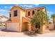 Two-story home featuring a two car garage, neutral stucco, and mature landscaping at 10457 Armand Ave, Las Vegas, NV 89129