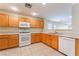 Clean kitchen with wood cabinets, tile floors, and white appliances at 10457 Armand Ave, Las Vegas, NV 89129