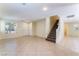 Spacious living room featuring tile flooring, staircase, and natural light from multiple windows at 10457 Armand Ave, Las Vegas, NV 89129