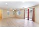 Bright living room featuring tile flooring, ceiling fan, multiple windows, and a sliding glass door at 10457 Armand Ave, Las Vegas, NV 89129