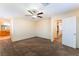Carpeted main bedroom with neutral walls, ceiling fan, and ensuite bathroom at 10457 Armand Ave, Las Vegas, NV 89129