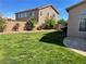 A green lawn, desert landscaping, and privacy wall border the backyard space at 10650 Robin Hill Ave, Las Vegas, NV 89129