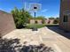 Spacious backyard with a basketball hoop on a paved patio and green lawn at 10650 Robin Hill Ave, Las Vegas, NV 89129