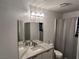 Bathroom with a modern vanity, large mirror, and a shower with curtain at 10650 Robin Hill Ave, Las Vegas, NV 89129