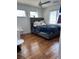 Comfortable bedroom featuring hardwood floors, a ceiling fan, and natural light from two windows at 10650 Robin Hill Ave, Las Vegas, NV 89129