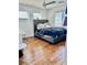 Bright bedroom features a tufted headboard and wood flooring at 10650 Robin Hill Ave, Las Vegas, NV 89129