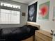 Contemporary bedroom featuring a black bed, minimalist decor, and a bright window at 10650 Robin Hill Ave, Las Vegas, NV 89129