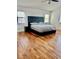 Bedroom with wood floors, large windows, and a padded headboard at 10650 Robin Hill Ave, Las Vegas, NV 89129