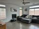 Living room featuring a modern ceiling fan, fireplace, and large sectional sofa with comfortable pillows at 10650 Robin Hill Ave, Las Vegas, NV 89129
