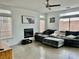 Cozy living room with modern ceiling fan, a fireplace, and large windows for natural light at 10650 Robin Hill Ave, Las Vegas, NV 89129