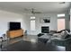 Spacious living room featuring a sleek fireplace, comfortable sofa, and a modern ceiling fan at 10650 Robin Hill Ave, Las Vegas, NV 89129
