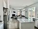 Open-concept living room with modern kitchen island, fireplace, and access to the backyard at 10650 Robin Hill Ave, Las Vegas, NV 89129