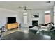 Comfortable living room with decorative fireplace, ceiling fan, and large windows for natural light at 10650 Robin Hill Ave, Las Vegas, NV 89129