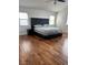 Spacious primary bedroom with dark wood floors, natural light, and comfortable sleeping arrangements at 10650 Robin Hill Ave, Las Vegas, NV 89129