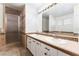 Bathroom featuring double sinks, a large mirror, and a walk-in shower at 1108 Sidehill Way, Las Vegas, NV 89110