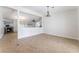 Open-concept living room with neutral tones, tile flooring, and a partial view of the kitchen at 1108 Sidehill Way, Las Vegas, NV 89110
