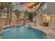 Backyard featuring a pool, spa, outdoor kitchen, slide, patio space, palm trees and fire pit at 11158 Antonine Wall Ct, Las Vegas, NV 89141