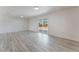 Spacious living room featuring wood-look floors, neutral walls, and sliding glass doors to a backyard at 1202 Arrowhead Ave, Las Vegas, NV 89106