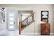 Bright home entryway featuring modern artwork and a staircase with wood and black metal railing at 1208 Crimson Sunbird St, North Las Vegas, NV 89084