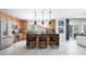 Modern kitchen features wood cabinetry, black countertops, pendant lighting, and stainless steel appliances at 1208 Crimson Sunbird St, North Las Vegas, NV 89084