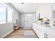 A light and airy bathroom features wood floors, a glass enclosed shower, and dual sinks with lots of storage at 1212 Crimson Sunbird St, North Las Vegas, NV 89084