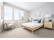 A cozy bedroom features a wooden bed frame, carpet and large windows to let the sun shine in at 1212 Crimson Sunbird St, North Las Vegas, NV 89084