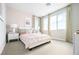 This bedroom features large windows, neutral carpet, and a comfy bed with lots of soft pillows at 1212 Crimson Sunbird St, North Las Vegas, NV 89084