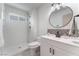 Well-lit bathroom featuring a walk-in shower and a vanity with a stylish round mirror at 1808 E Saint Louis Ave, Las Vegas, NV 89104
