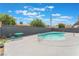 Backyard pool with a dark grey fence, a table, and a couple of chairs with clear skies above at 1808 E Saint Louis Ave, Las Vegas, NV 89104