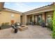 Charming backyard with a stone fire pit, comfortable seating, decorative sun art, and mature landscaping at 21 Grand Masters Dr, Las Vegas, NV 89141