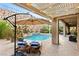 Serene backyard with a pool, spa, lounge chairs, and rock wall, perfect for relaxation at 21 Grand Masters Dr, Las Vegas, NV 89141