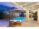 Beautiful backyard features a pool, hot tub, lounge chairs, a built-in BBQ, and rock wall at 21 Grand Masters Dr, Las Vegas, NV 89141