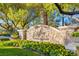 Stone sign reads 'Spa Southern Highlands' with flowerbed in a beautiful outdoor setting with luscious green trees at 21 Grand Masters Dr, Las Vegas, NV 89141