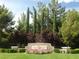 Stone Southern Highlands Golf Club entrance sign with colorful flower bed, manicured lawn, and mature trees at 21 Grand Masters Dr, Las Vegas, NV 89141
