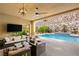 Stylish outdoor patio featuring comfortable seating, a ceiling fan, and views of the pool at 21 Grand Masters Dr, Las Vegas, NV 89141