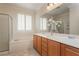 Bathroom featuring double sinks, bathtub, shower with glass door and window with plantation shutters at 2163 Bannerwood St, Henderson, NV 89044