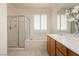 Bathroom featuring bathtub and separate shower with glass doors, double sinks and plantation shutters at 2163 Bannerwood St, Henderson, NV 89044