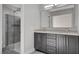 Bathroom featuring a double vanity with modern fixtures and tiled shower with glass door at 2212 Warm Walnut Dr, Las Vegas, NV 89134
