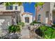 Close up shot of the charming stucco home's front entrance with gated walkway and landscaping at 2212 Warm Walnut Dr, Las Vegas, NV 89134