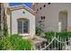 Close up view of the stucco home's charming, gated walkway and lush landscaping at 2212 Warm Walnut Dr, Las Vegas, NV 89134