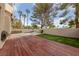 This backyard features a wooden deck, grass area, barbecue grill, patio area, and desert landscaping at 2416 Sun Shores Dr, Las Vegas, NV 89128
