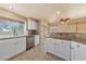 Well-lit kitchen with white cabinets, granite countertops, and modern stainless steel appliances at 2416 Sun Shores Dr, Las Vegas, NV 89128
