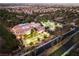 An aerial view showcases a community building, trees, and a parking area at dusk at 2528 Sunup Dr, Las Vegas, NV 89134